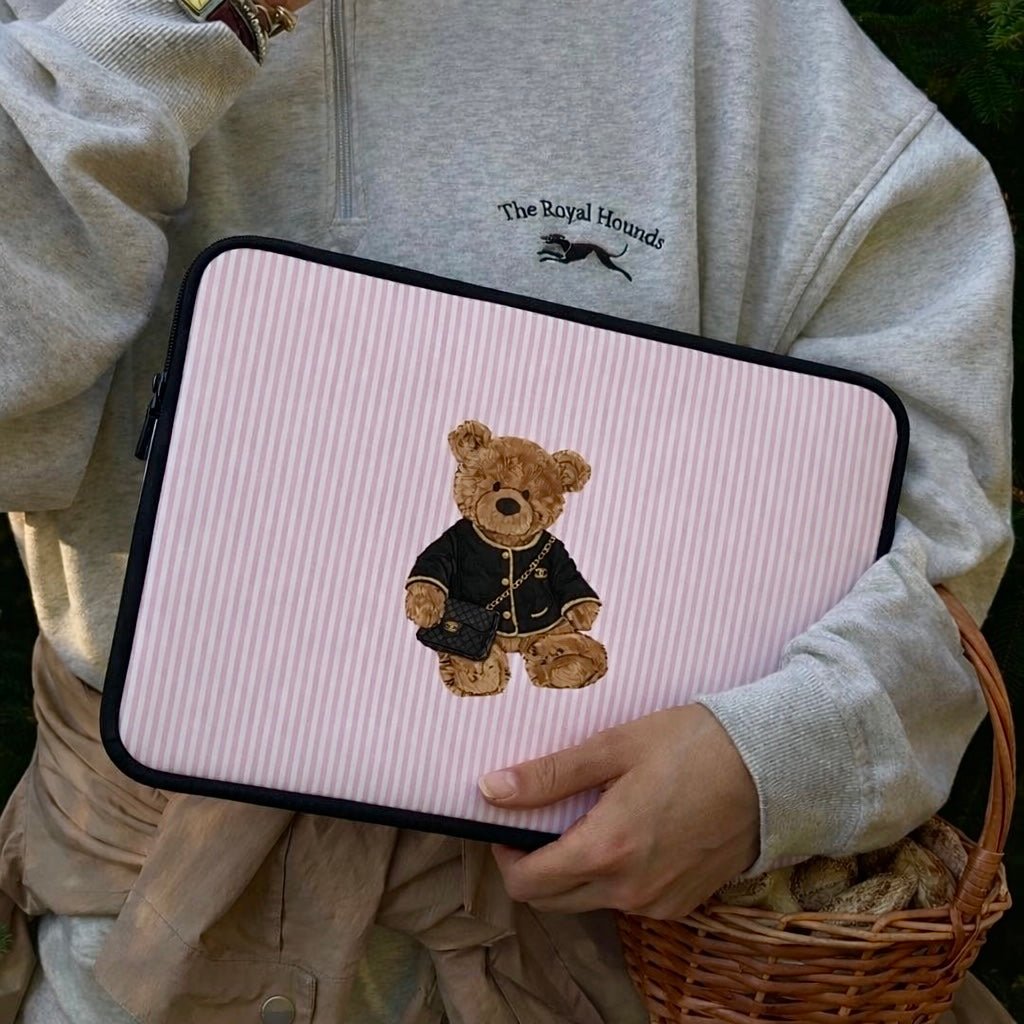 Pink striped neoprene sleeve with teddy bear applique and black zipper, held in hand