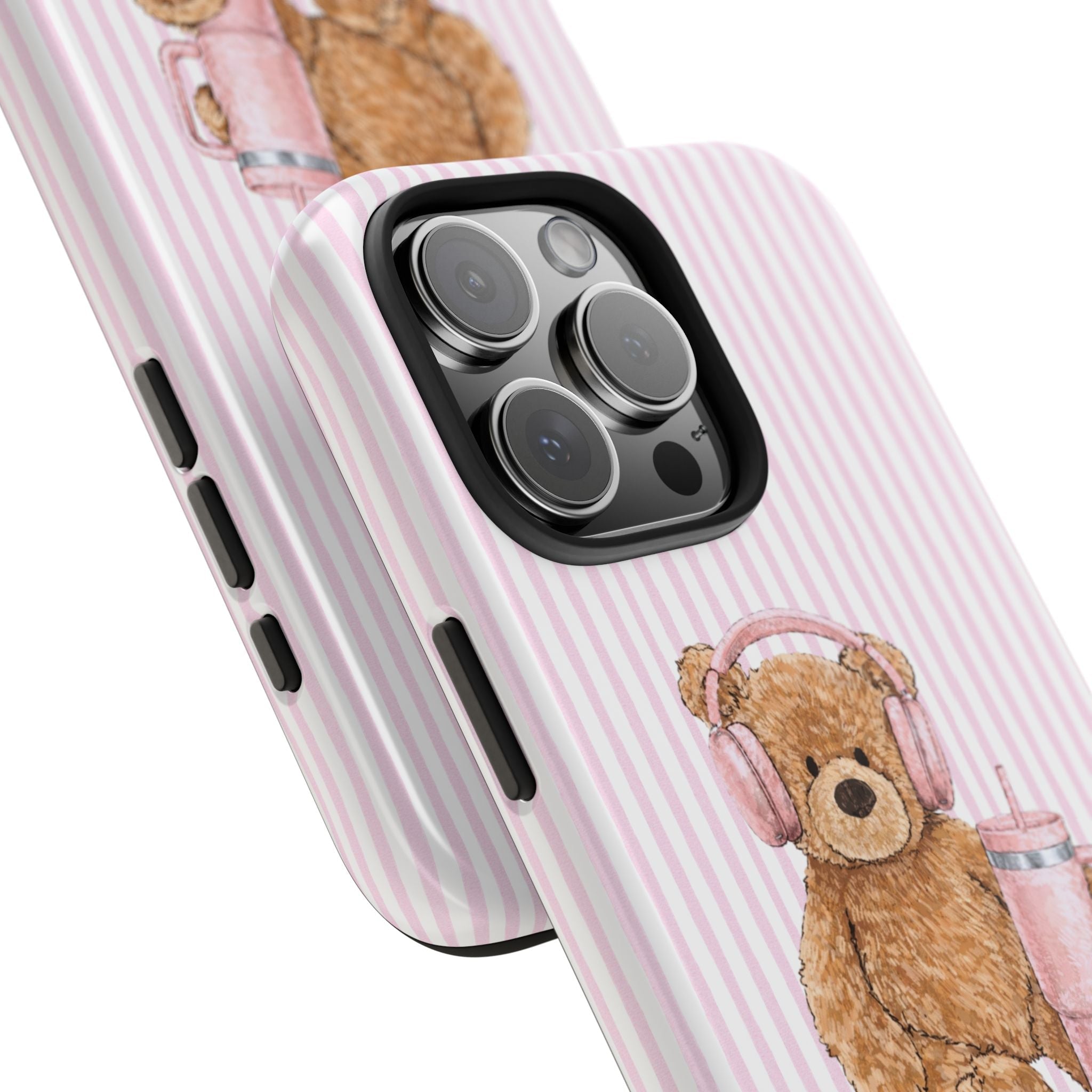 Angle close-up of pink striped case with teddy bear headphones near camera lenses