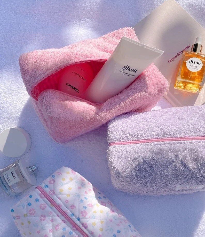 Pink terrycloth gingham pouch with zipper opening, toiletries inside