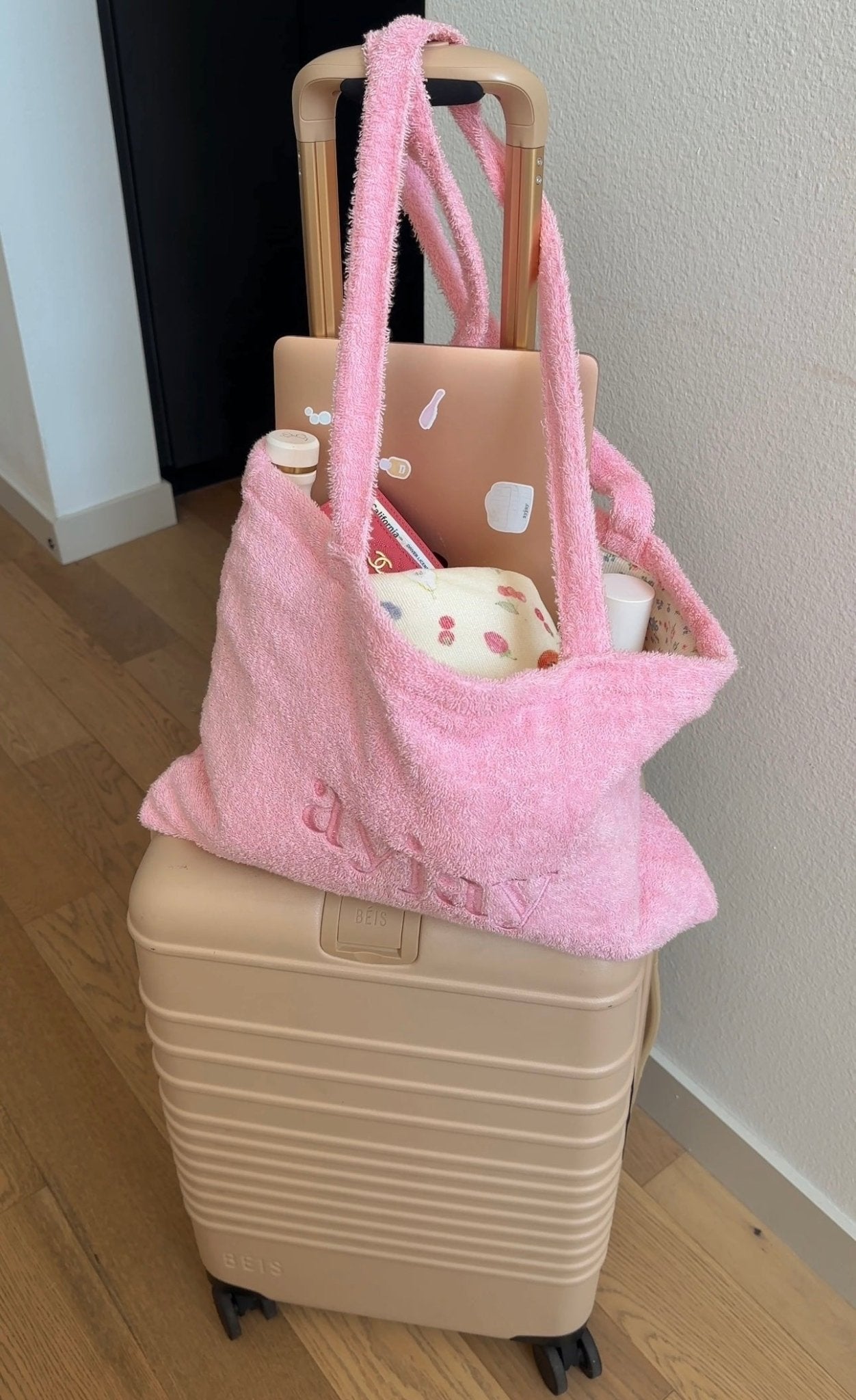 Pink terrycloth tote bag with top handles, “love” logo on front, open-top design.