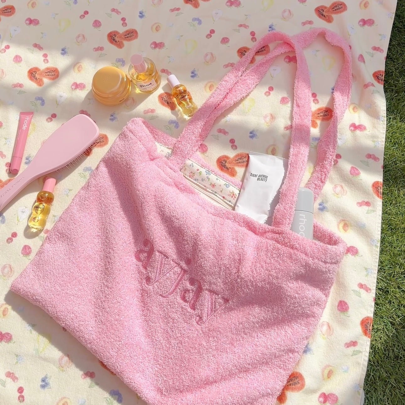 Pink terrycloth tote bag with front “love” embossed detail and open interior pocket.
