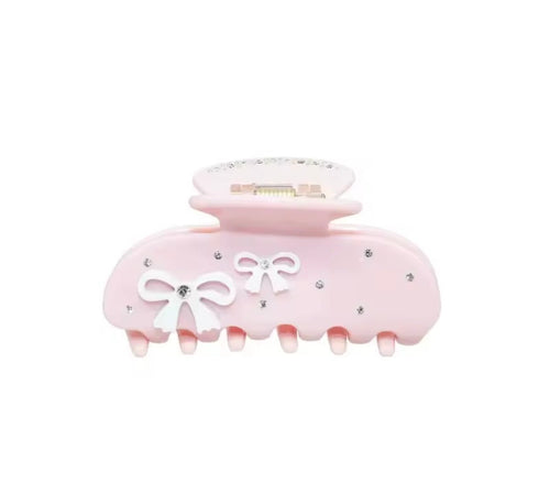 Light pink hair claw with white bows and rhinestone accents, wide grip teeth