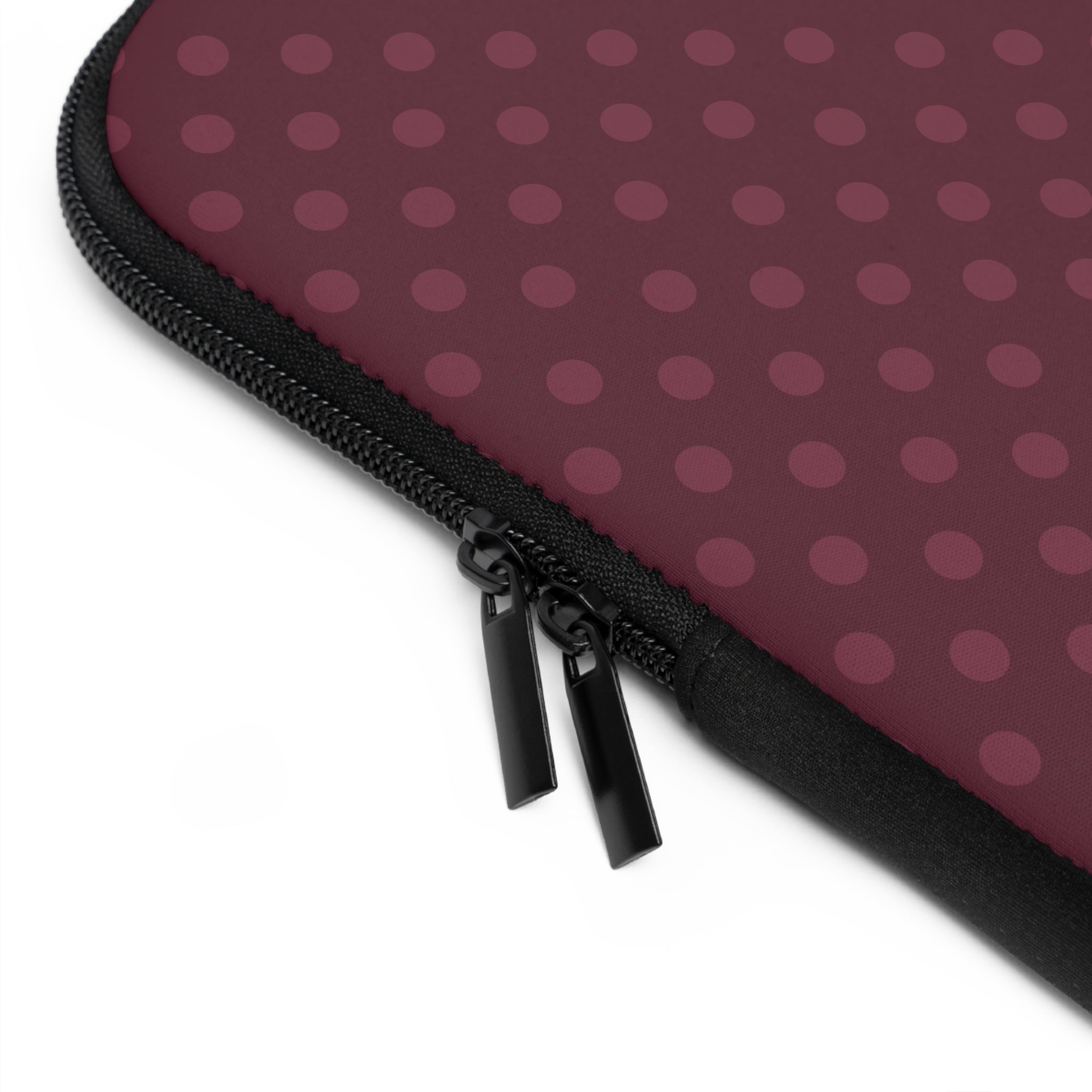 Close-up: black zipper on plum polka-dot neoprene sleeve edge.