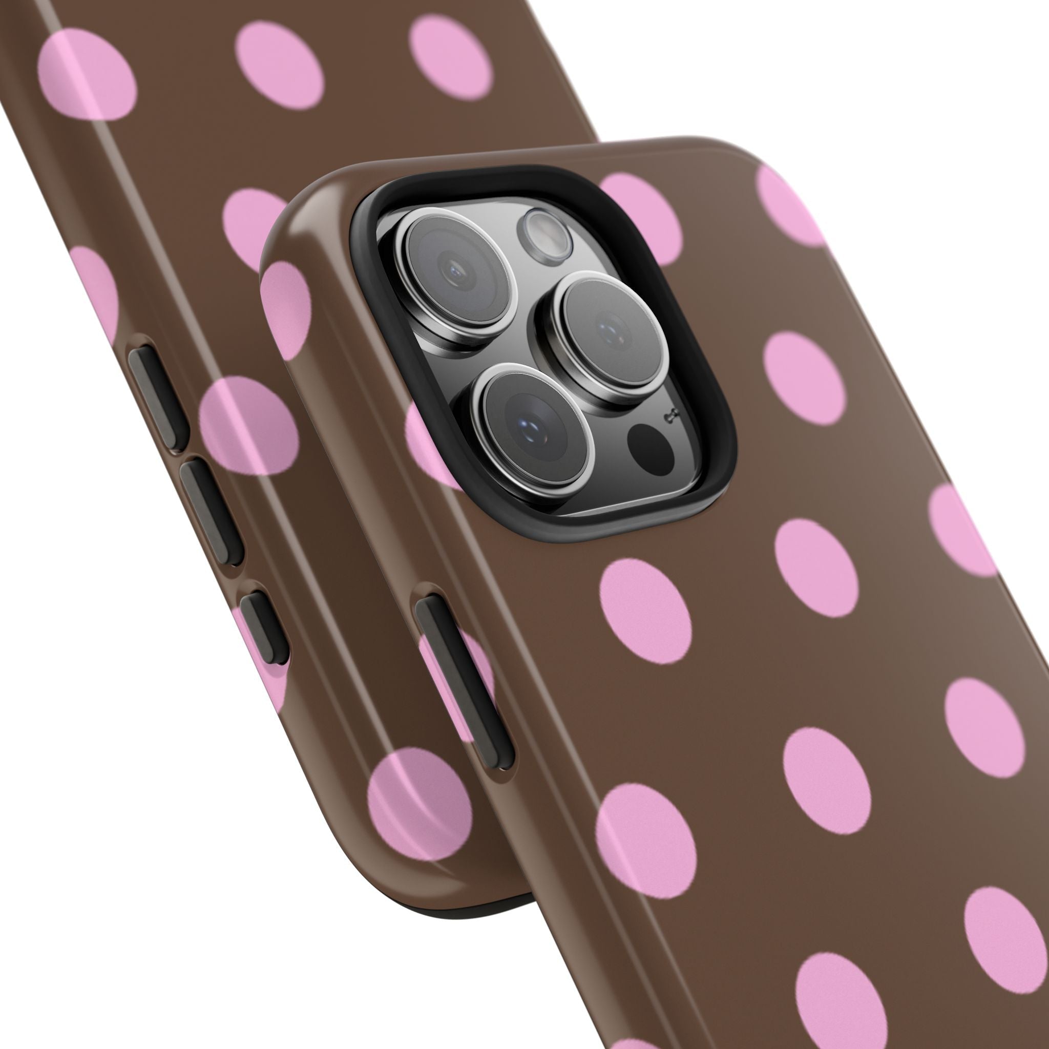 Close-up of polka dot phone case camera cutout on dark brown with pink dot pattern