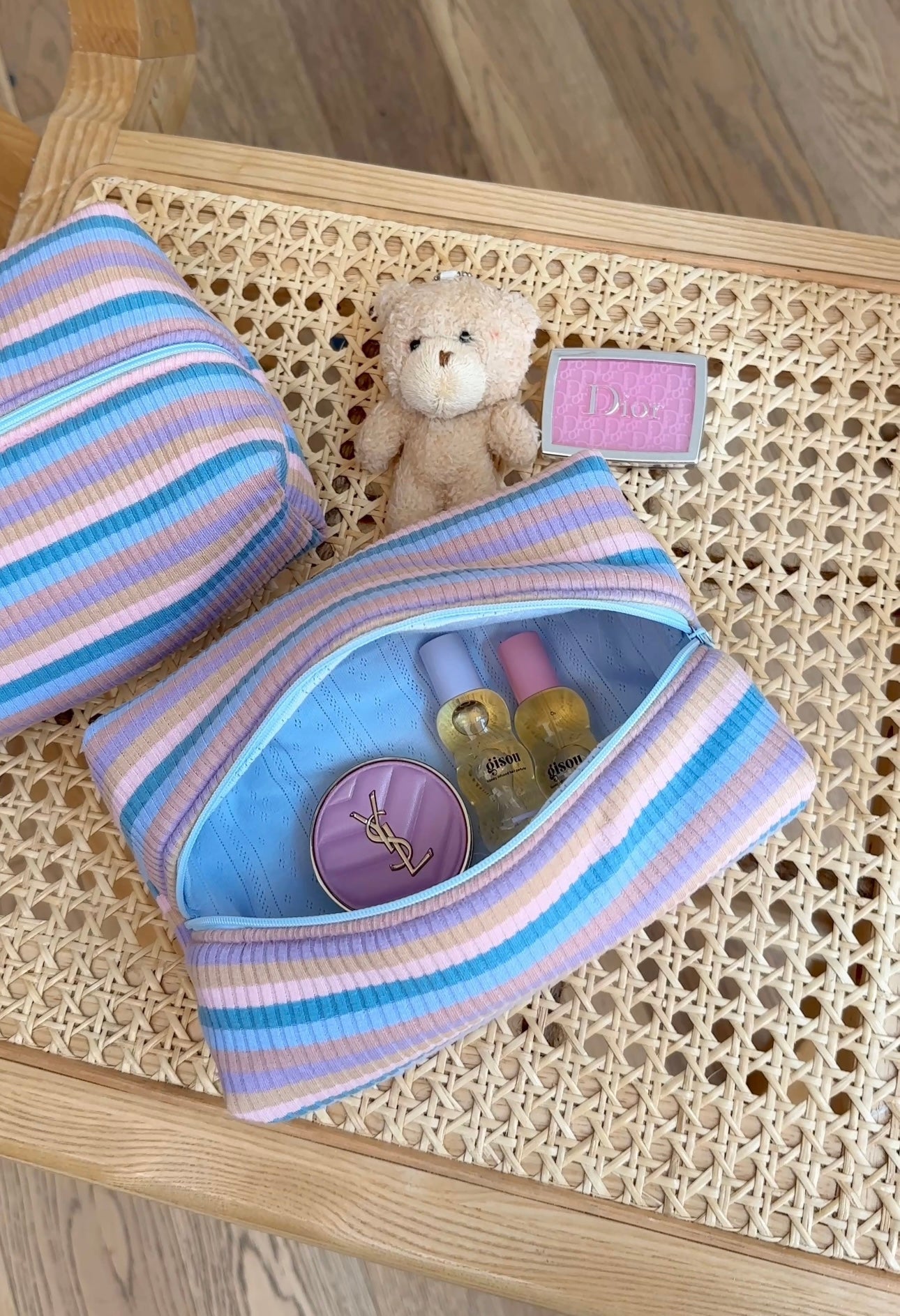 Blue and purple striped pouch with snap top, open to show small items inside