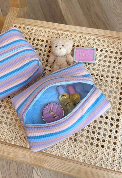 Blue and purple striped pouch with snap top, open to show small items inside