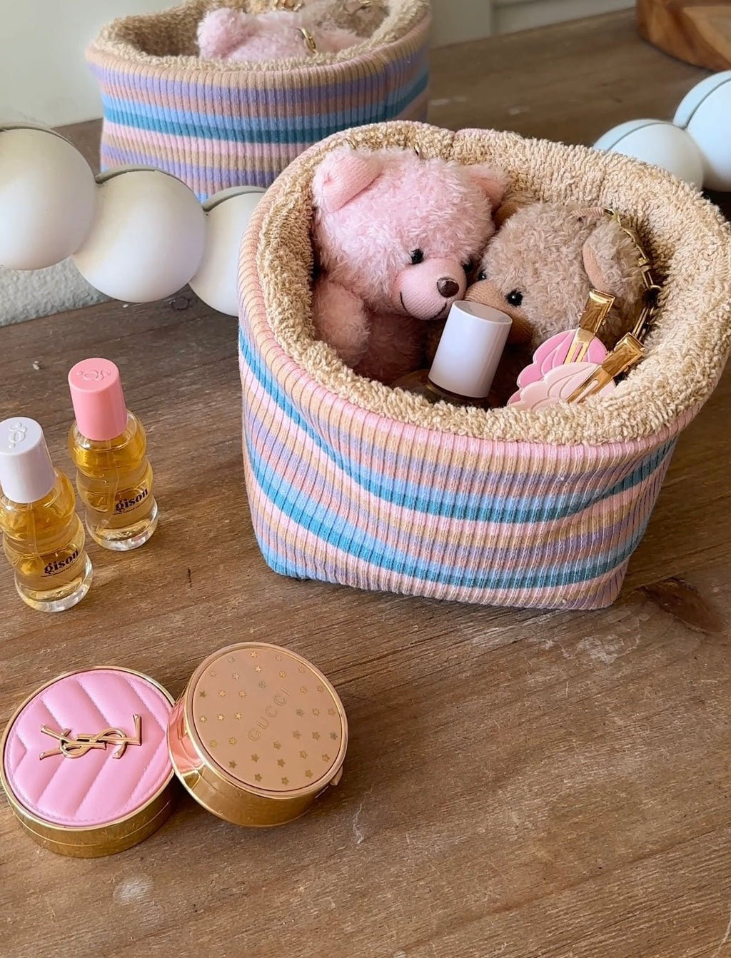 Striped knit organizer bin with teddy bears and plush inside, pastel purple and blue