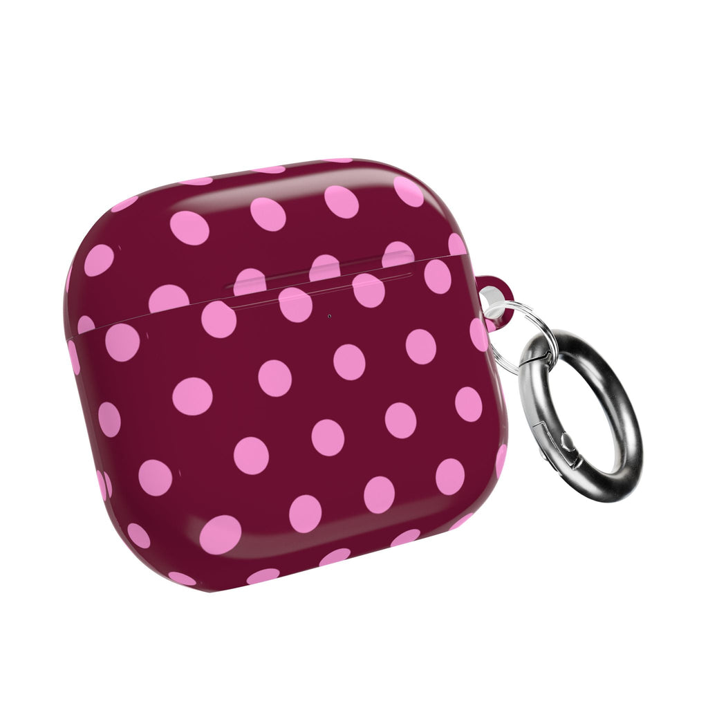 Maroon AirPods case with pink polka dots and metal keyring loop on side