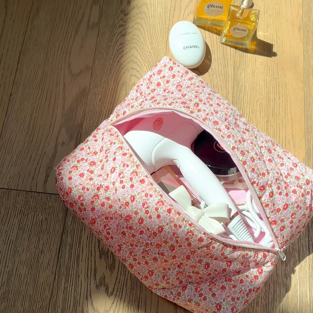 Floral zip case open, showing hair styling tools and accessories inside