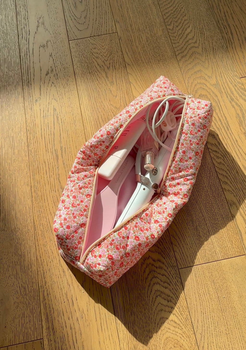 Floral zip pouch closed, side view with handles and zipper edge visible