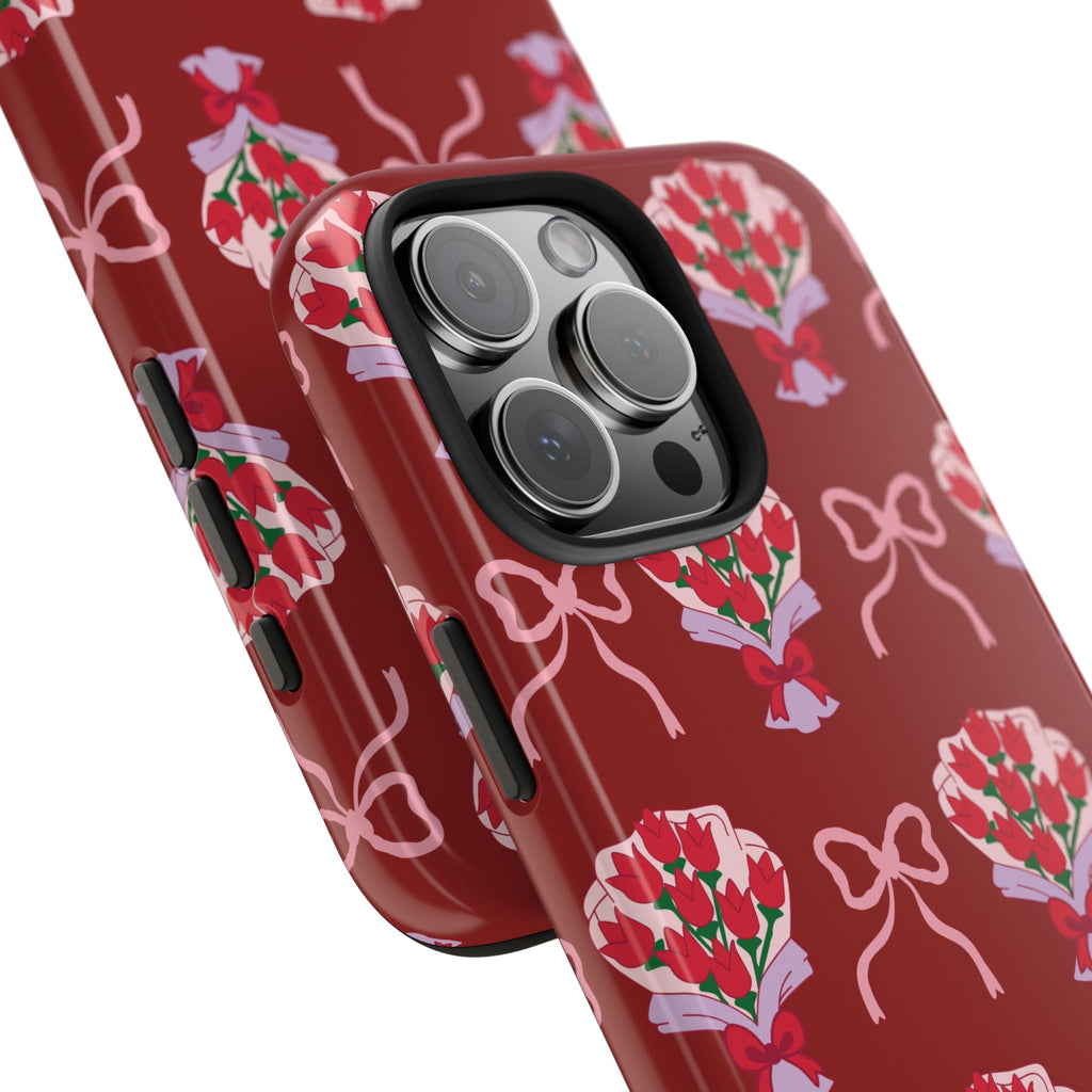 Red phone case angled view with bouquet-and-bow print and camera cutout