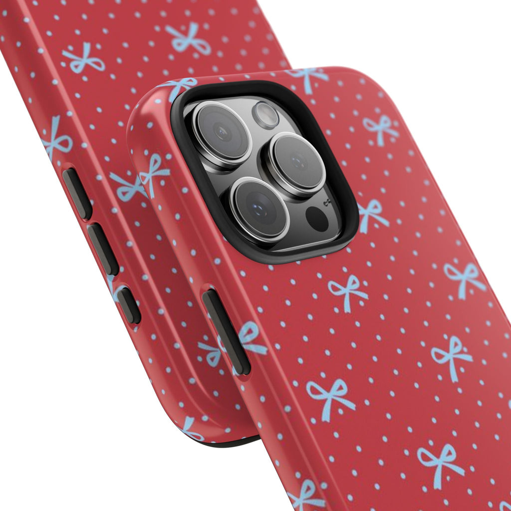 Angled red polka-dot phone case with blue bows and camera lens cutouts