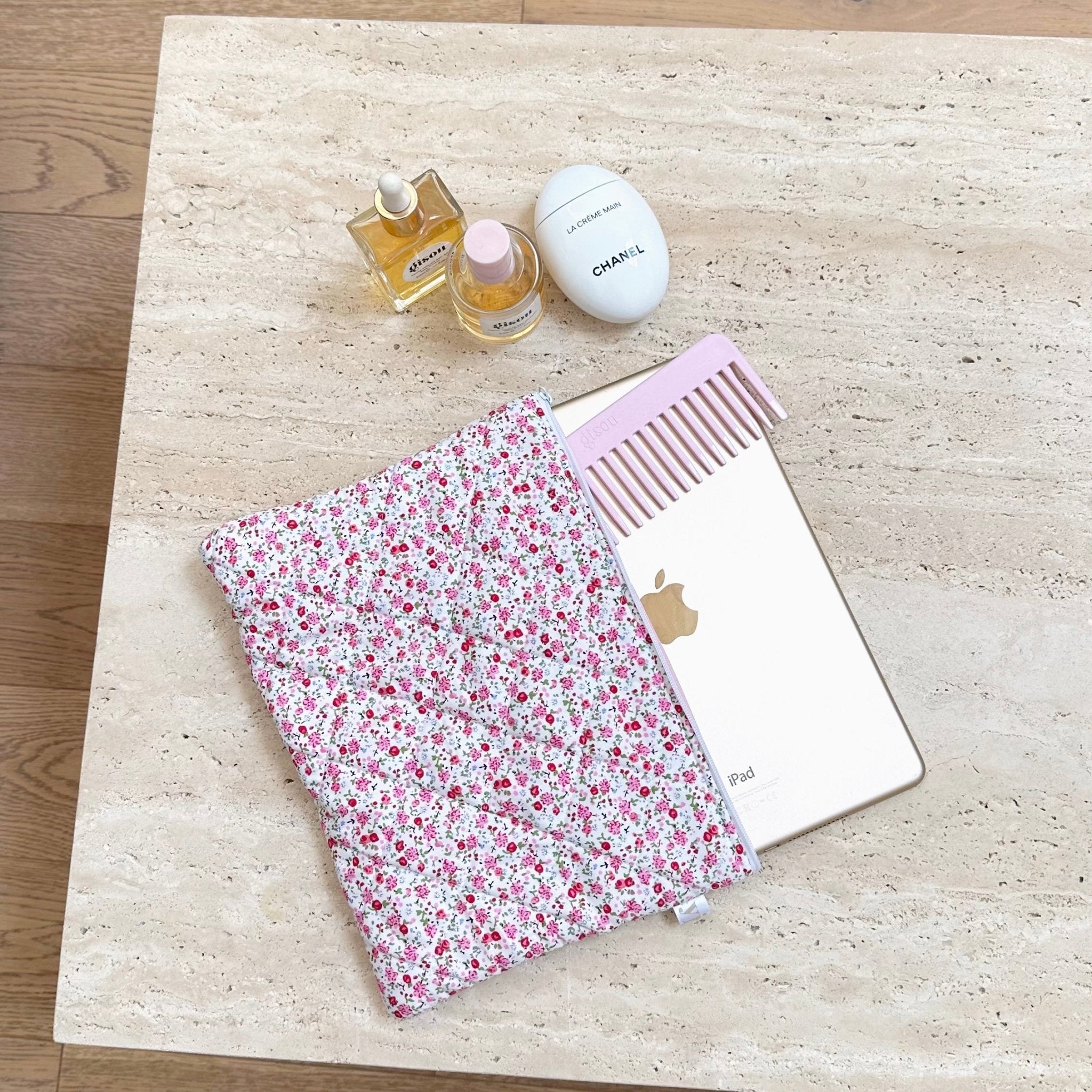 Floral zip pouch and small accessories on counter, white trim and pink interior lining.