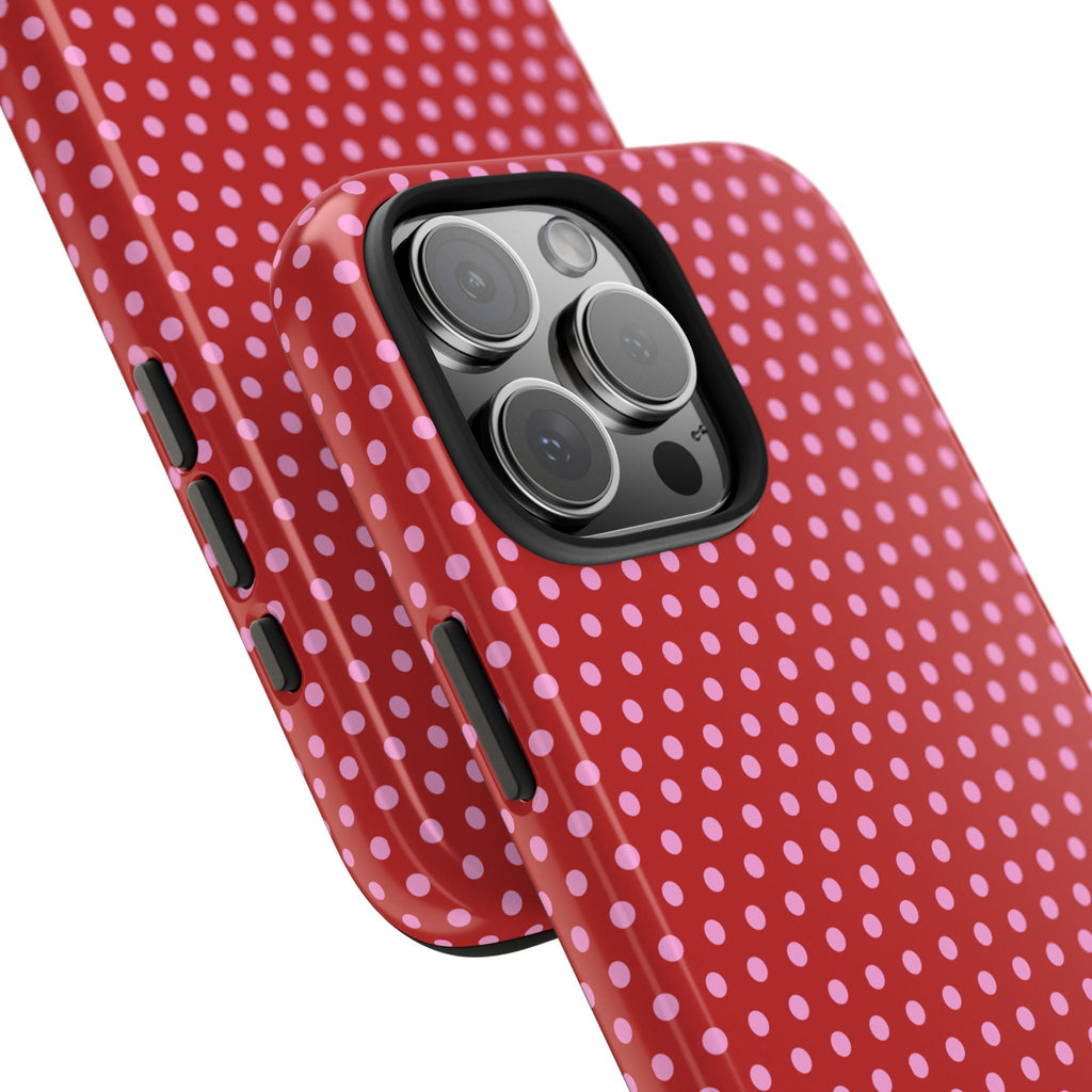 Angled red and pink polka dot phone case with side buttons and camera lens