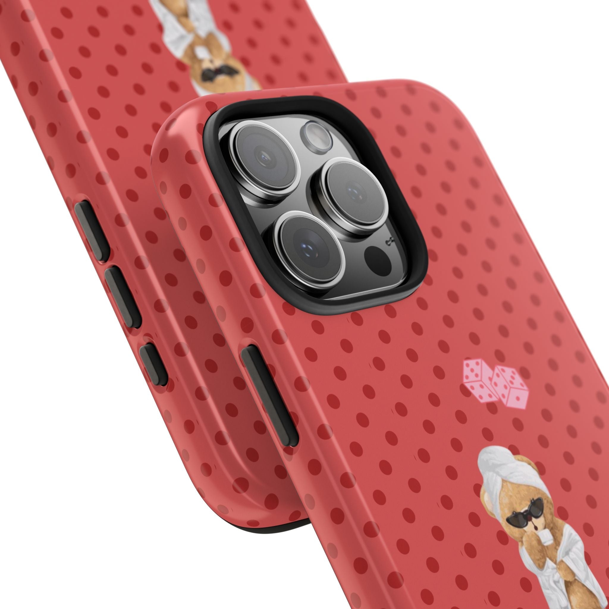 Red polka-dot phone case at angle, showing side buttons and teddy bear artwork