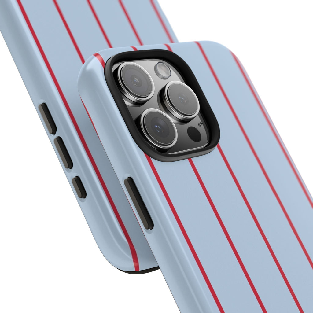 Angled close-up of sky blue phone case with red vertical stripes, triple camera cutout