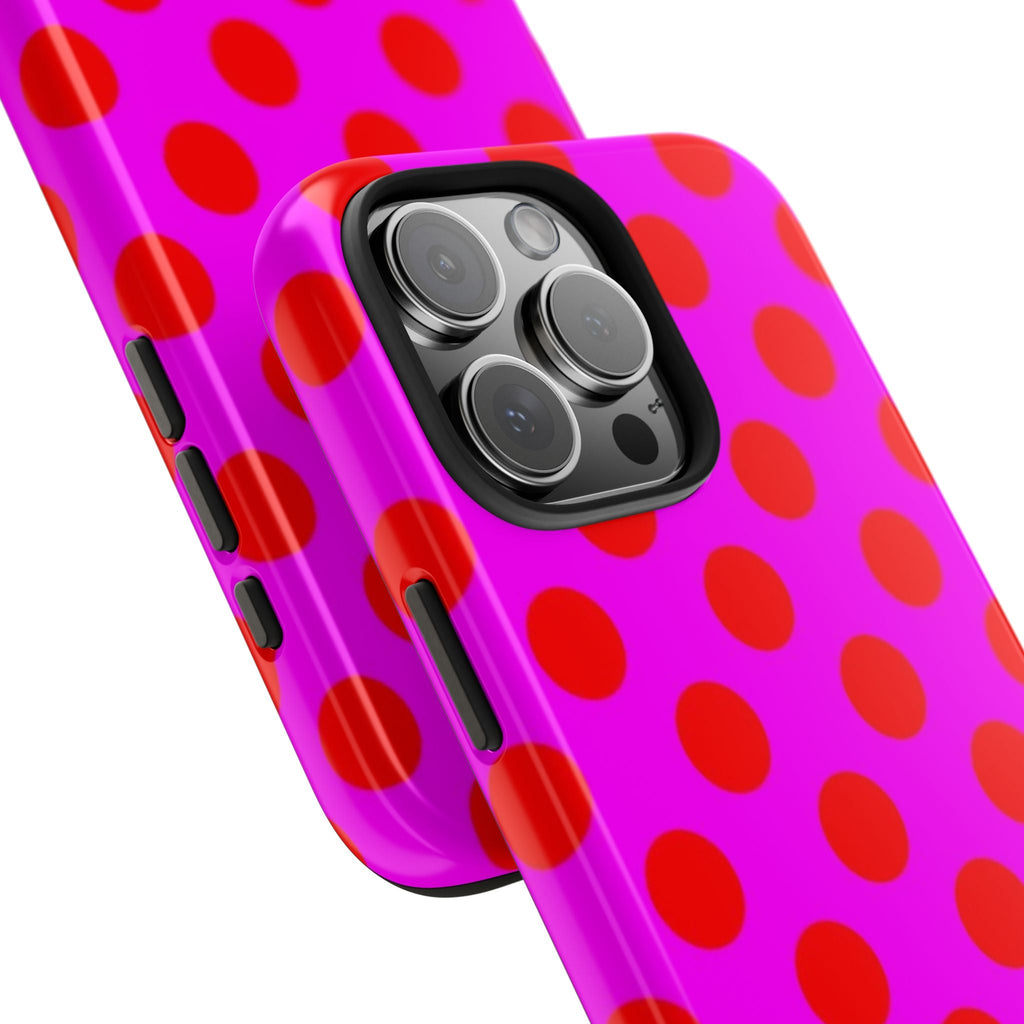 Pink phone case with red polka dots, angled view showing side button cutouts