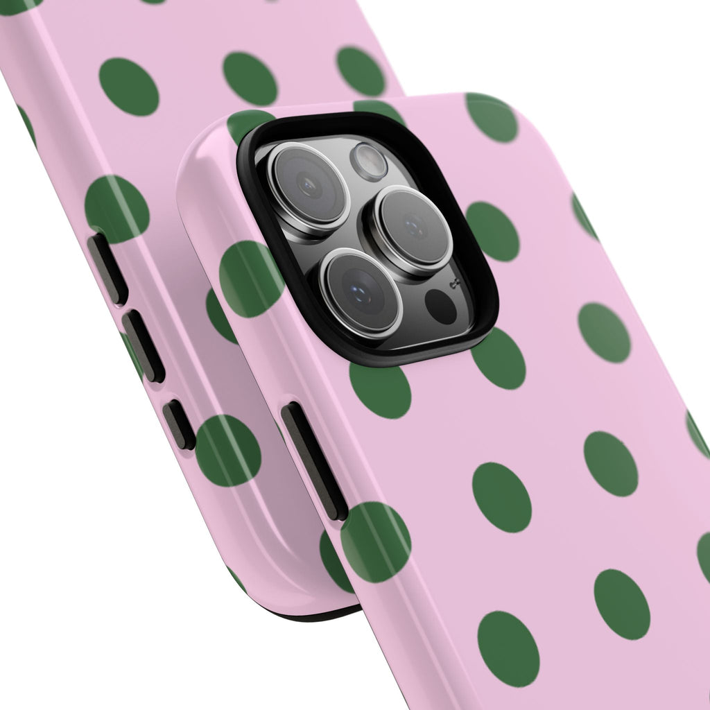 Angled view of pink phone case with green polka dot pattern and camera lenses