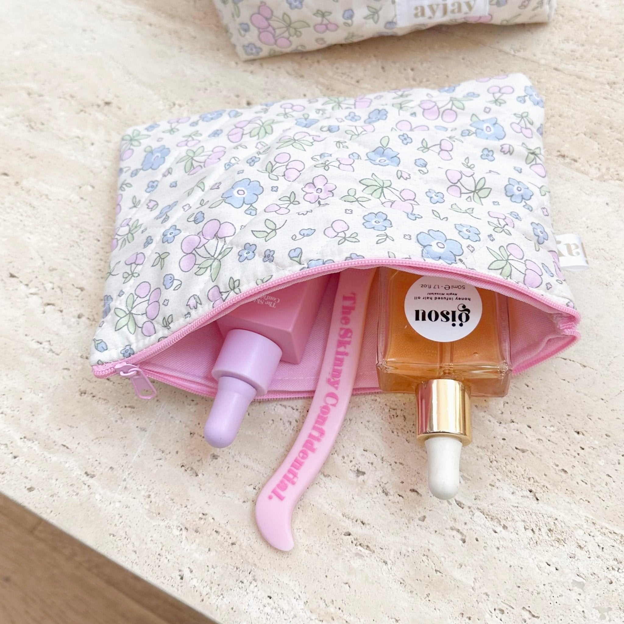 White floral zip pouch with blue and purple flowers, pink interior pocket and zipper