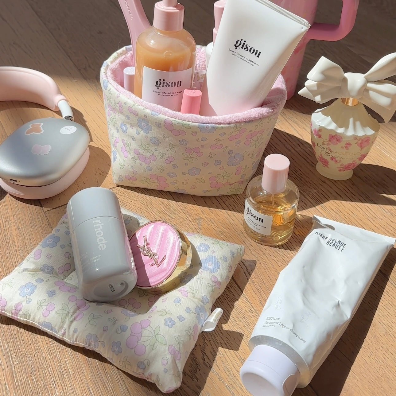 Pastel floral cloud coaster pouch holding bottles, with pink circular logo patch