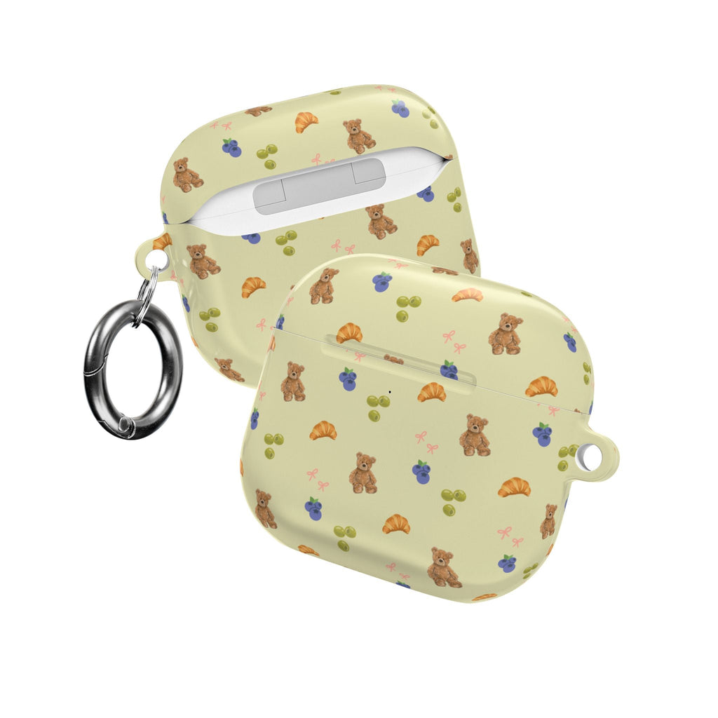 Light olive AirPods case with teddy/fruit/croissant pattern; closed, with keyring