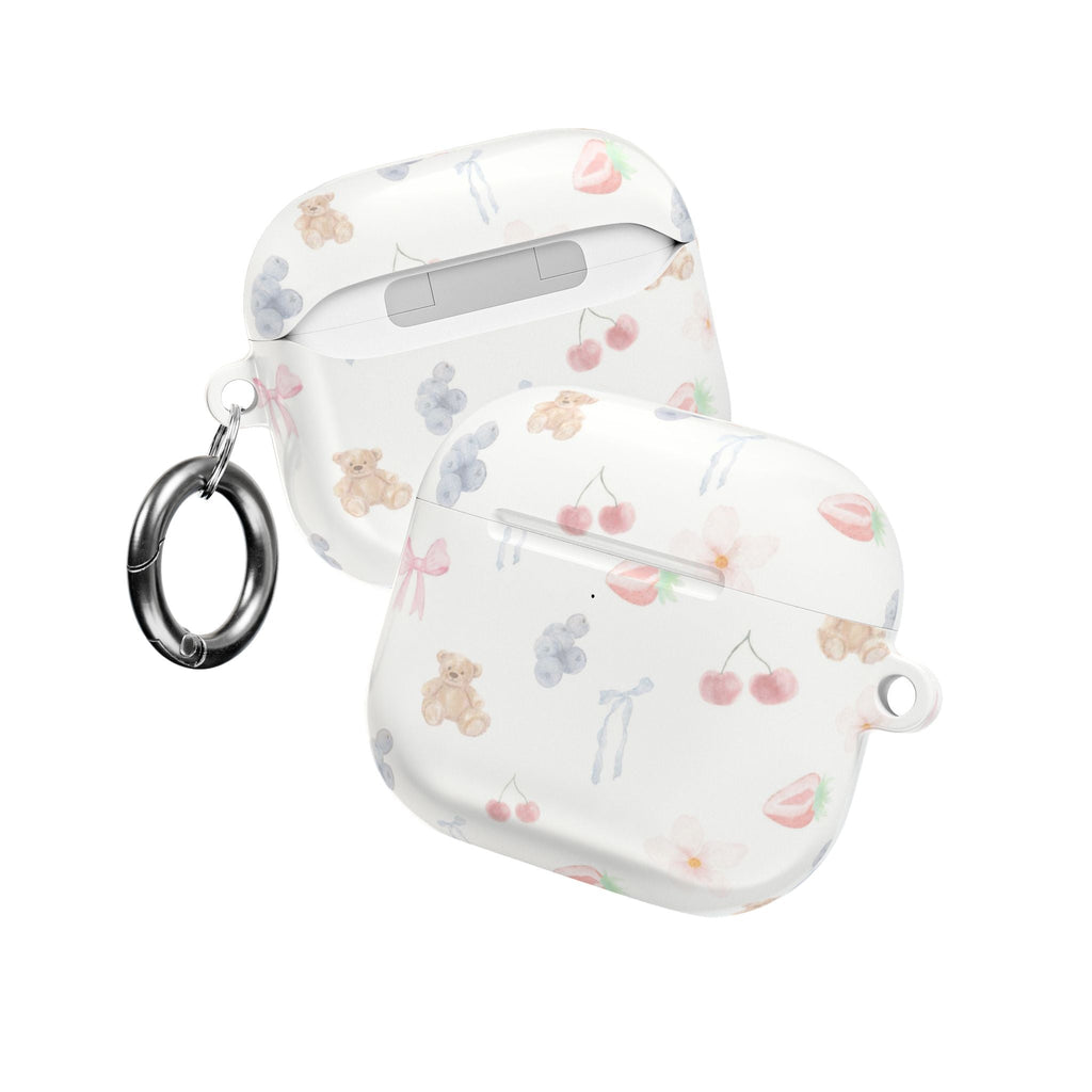 White AirPod case with pastel bear and bow print; keyring loop and lid front shown