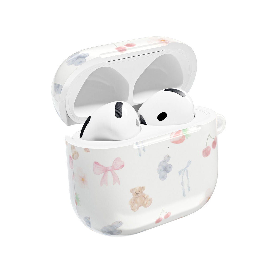 White AirPod case with pastel bear, bow, and heart print; earbuds docked