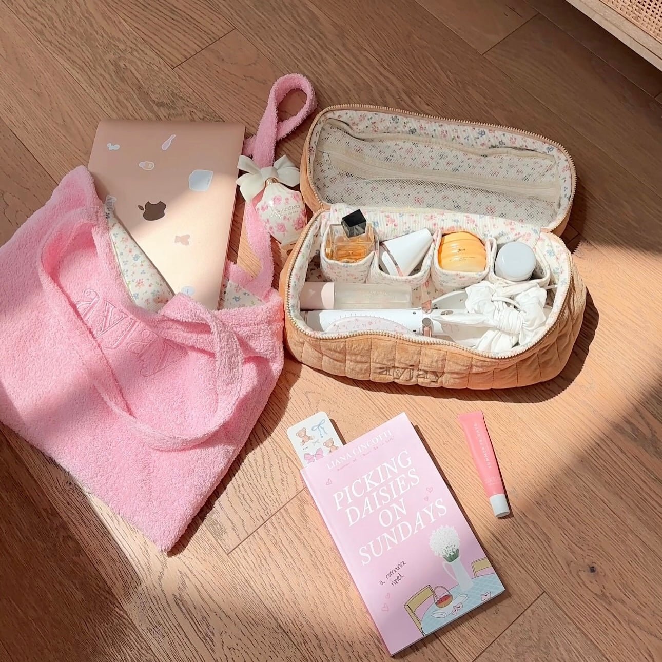 Tan floral vanity bag with rounded top, open zipper compartments and included accessories.