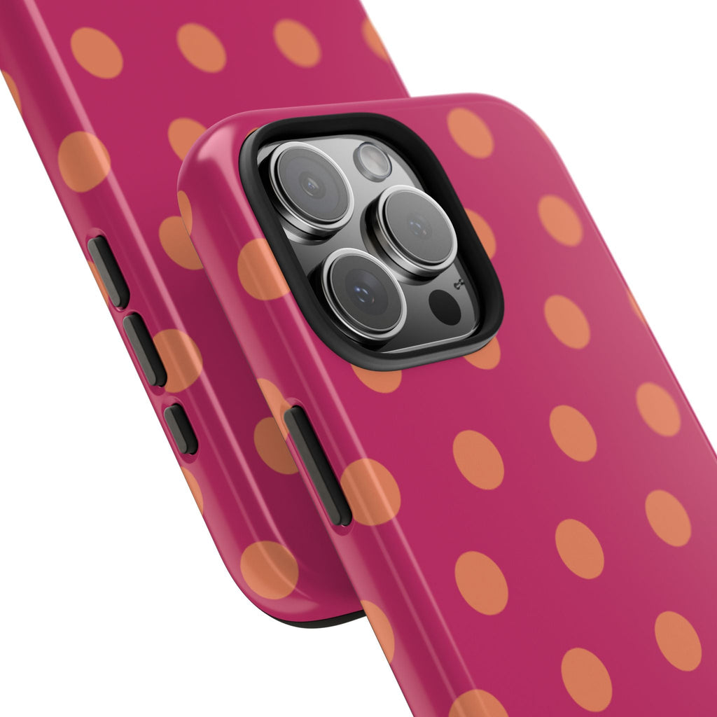Close-up of orange polka dot phone case with camera bump and side buttons