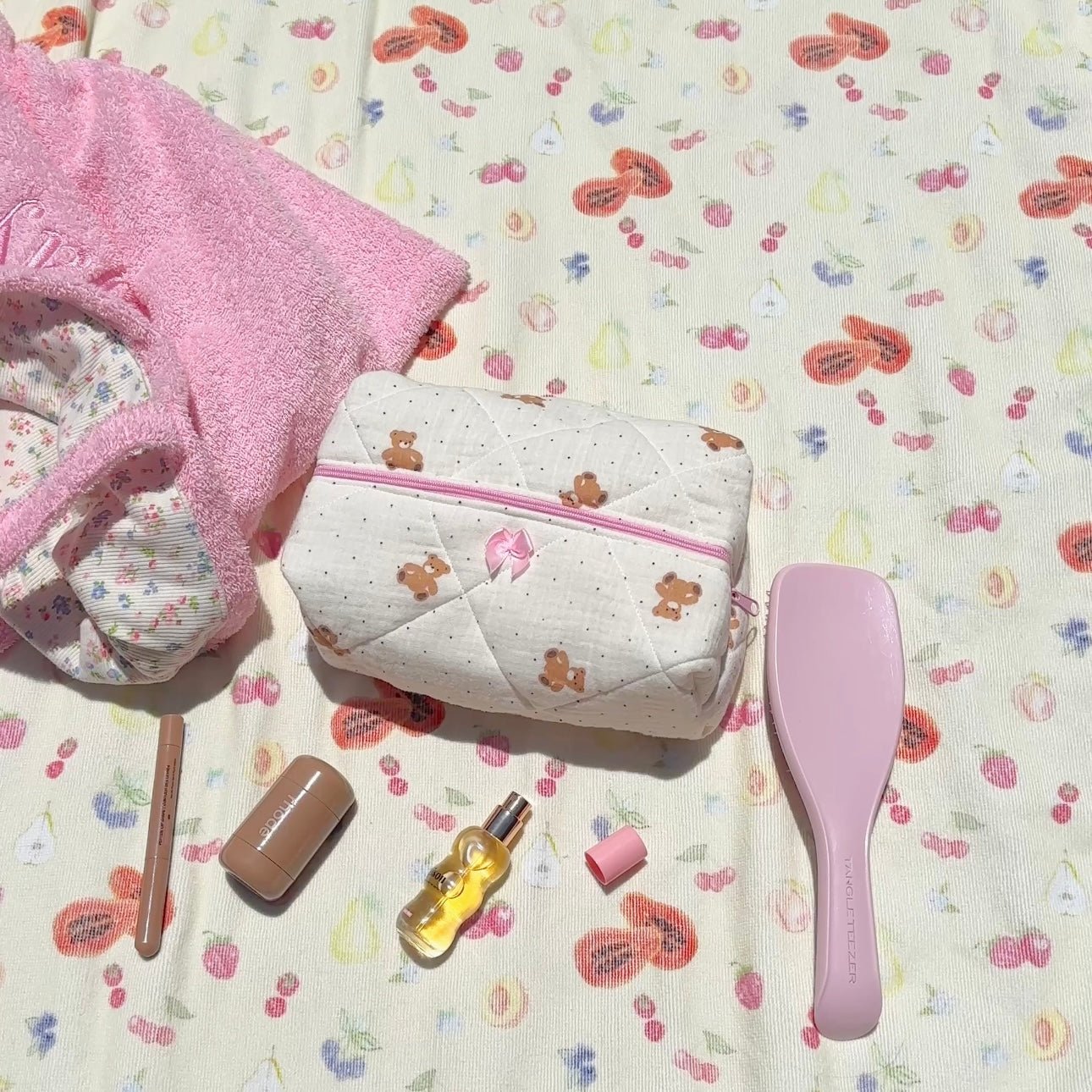 Quilted white pouch with teddy bear print, pink zipper trim and front opening