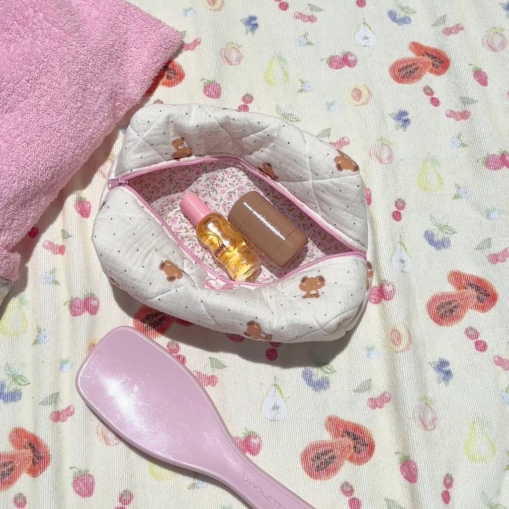 Open quilted teddy bear pouch with pink trim, inner pocket holds small bottles