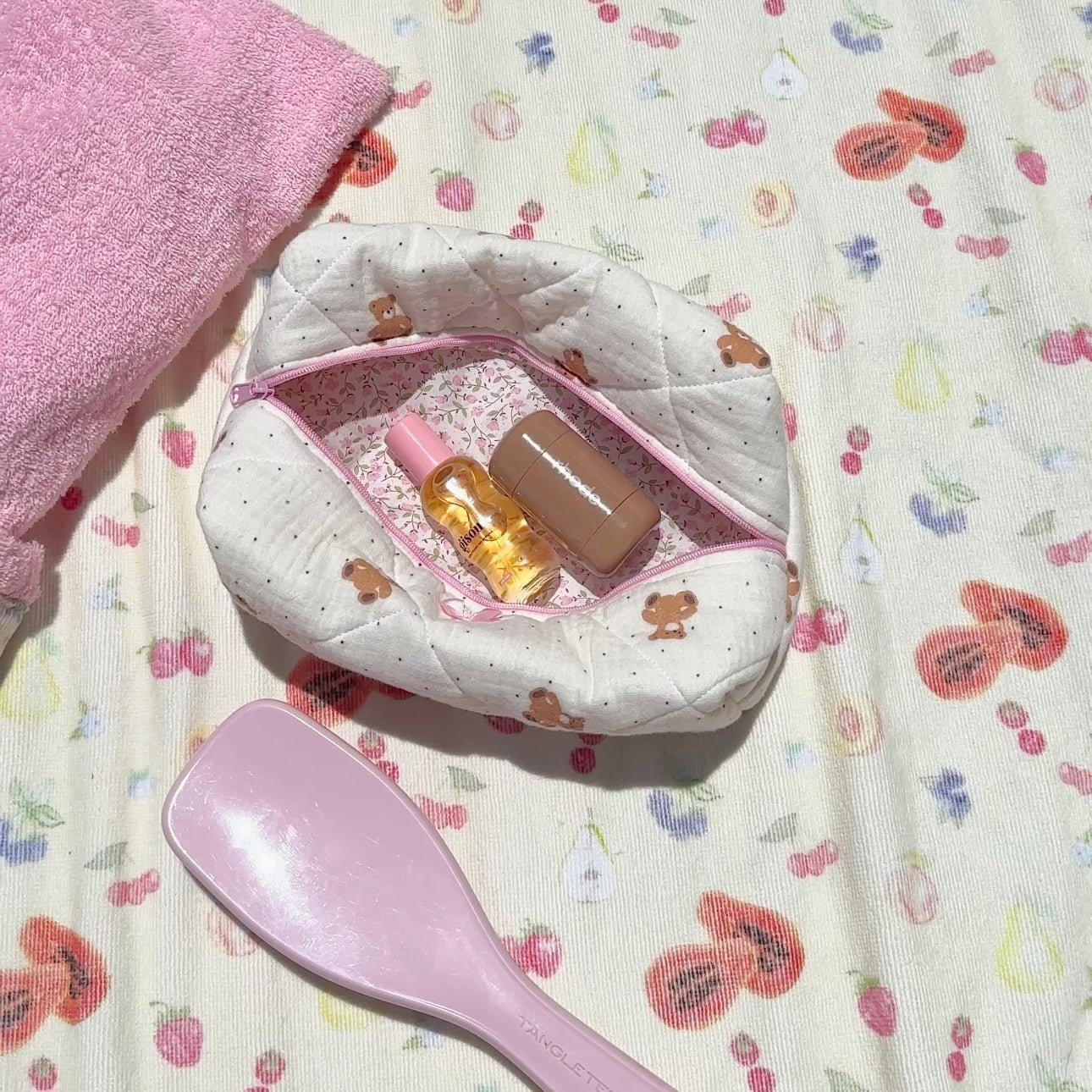 Open quilted teddy bear pouch with pink trim, inner pocket holds small bottles