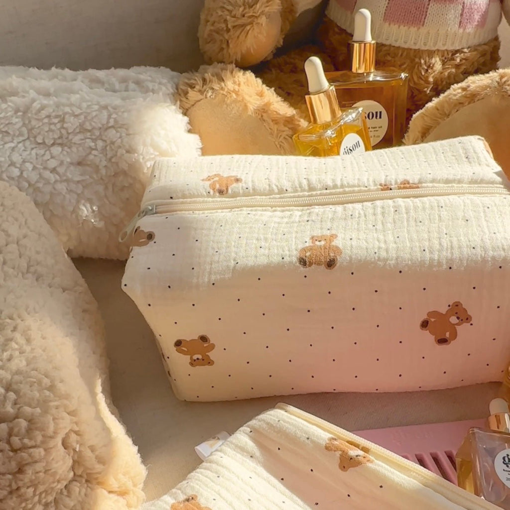 Cream zip pouch with teddy bear print and tiny dots, front view with clasp zipper