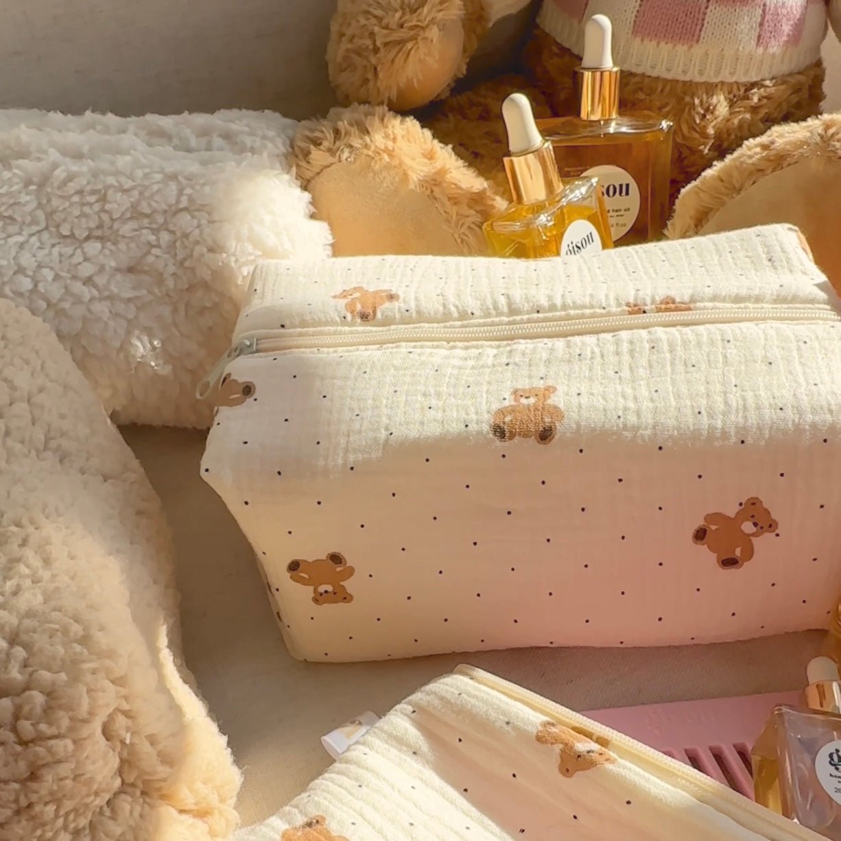 Cream zip pouch with teddy bear print and tiny dots, front view with clasp zipper