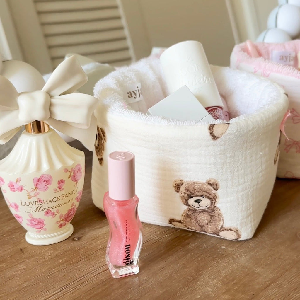 White plush teddy bear organizer bin with ribbon handle and teddy appliqué, open top.