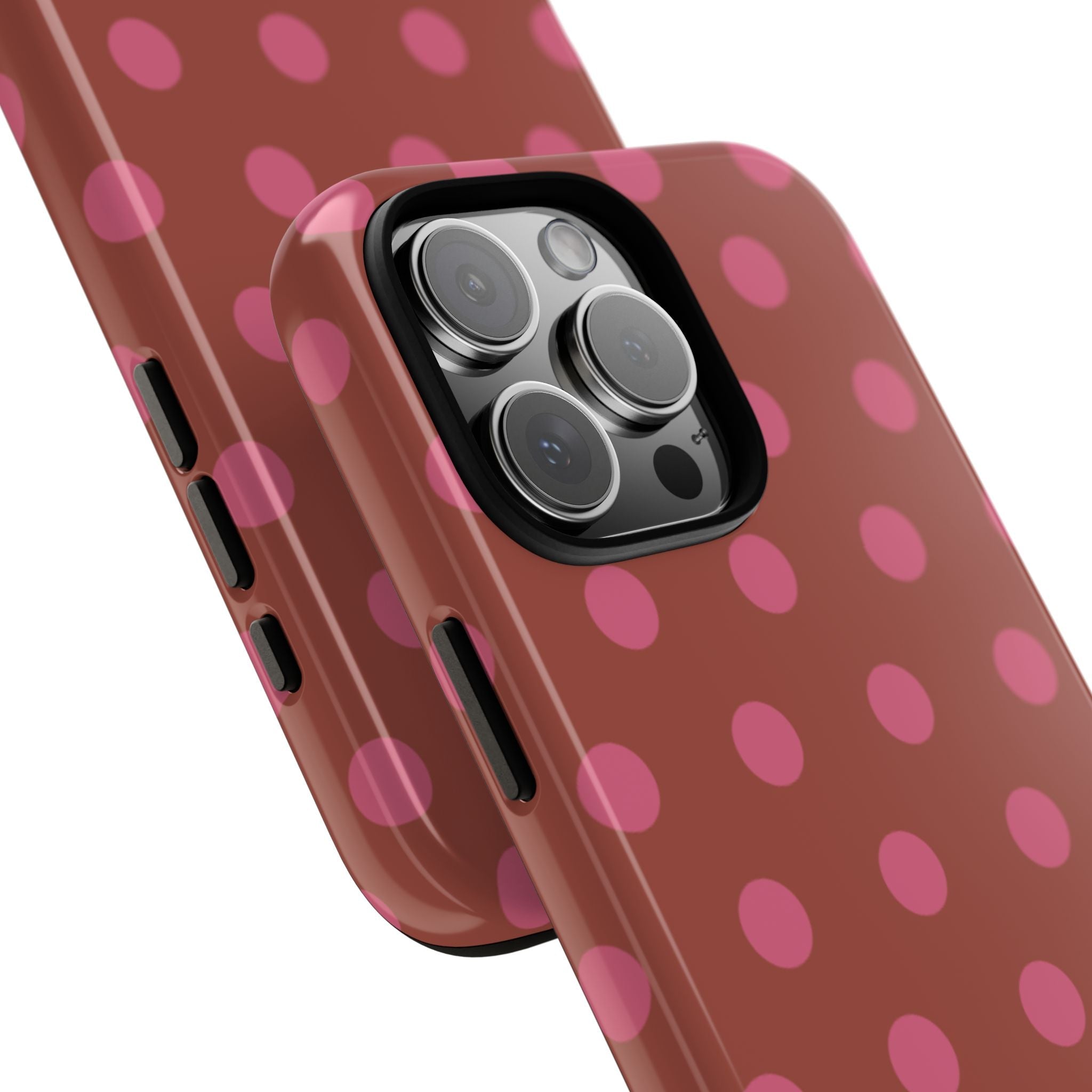 Terracotta polka dot phone case showing side buttons and raised camera module