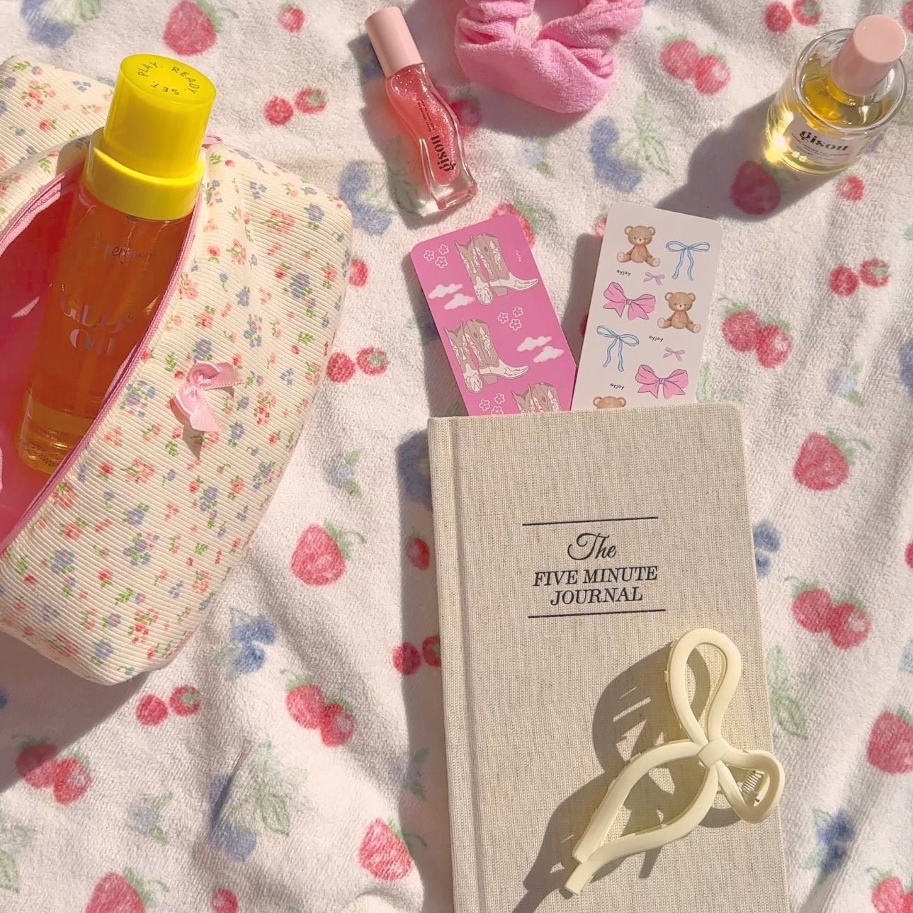 Cream “Five Minute Journal” cover with a pink ribbon bookmark card peeking out.