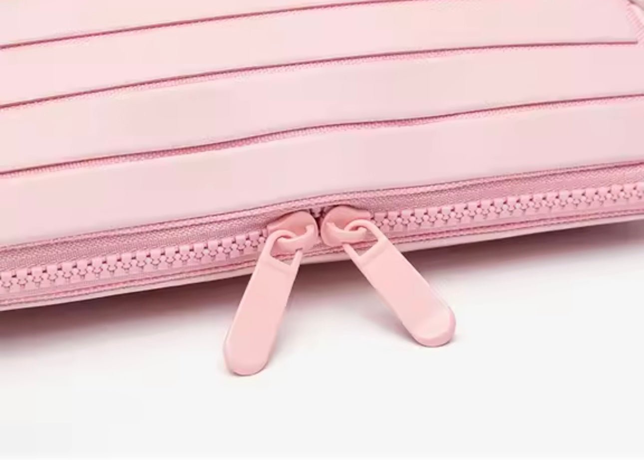 Close-up of pink zipper pull tabs on compact flex case