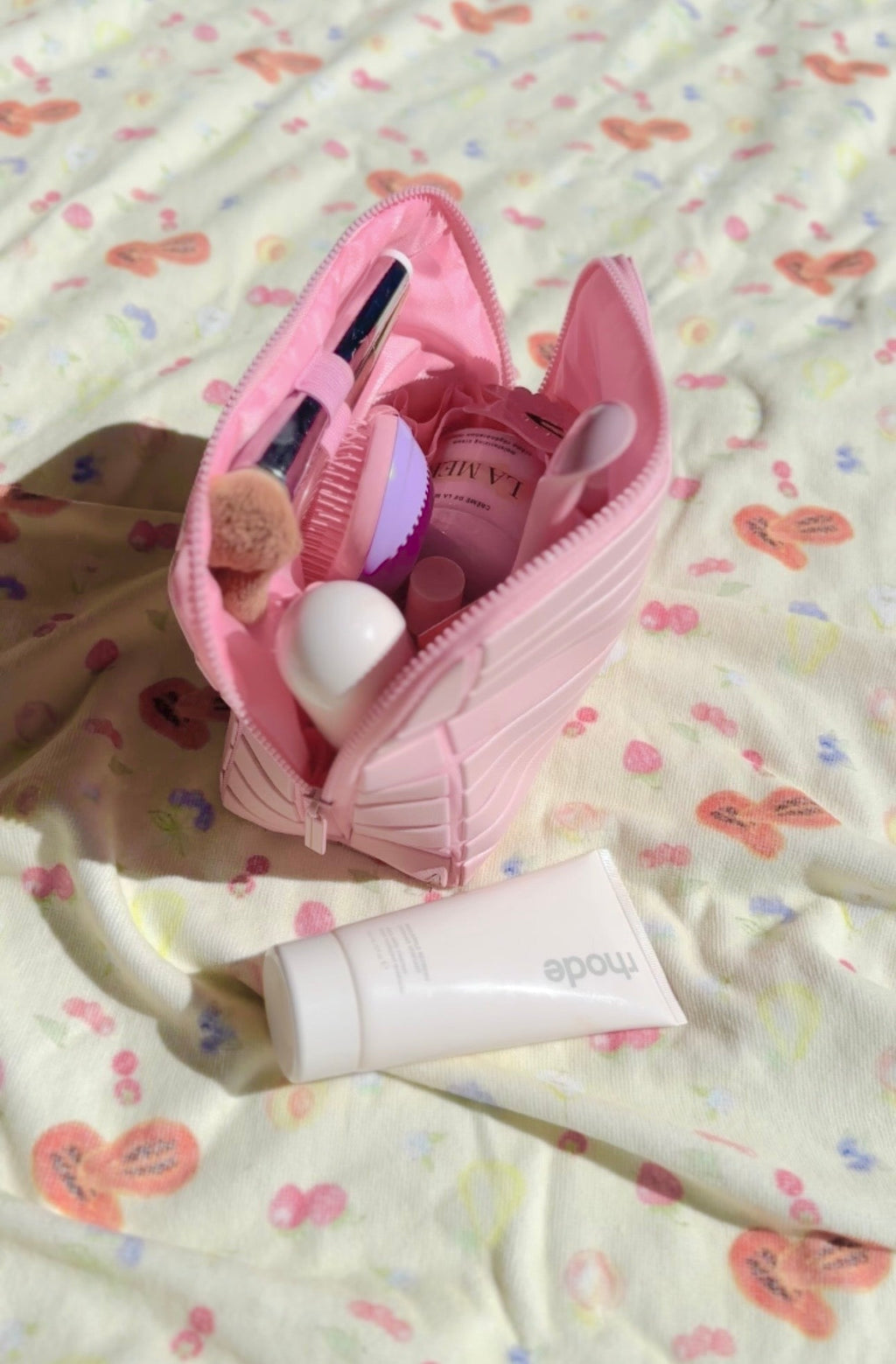 Open pink compact flex case organizer with compartments and beauty tools inside