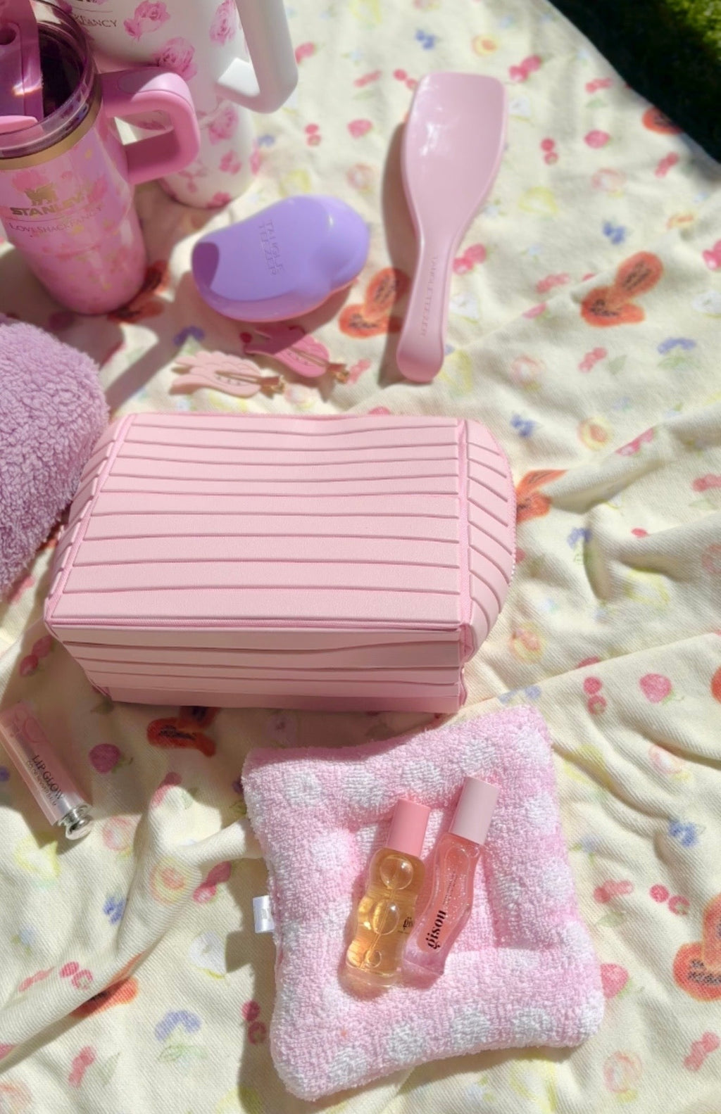 Pink compact flex case with striped lid and attached brush holder, closed