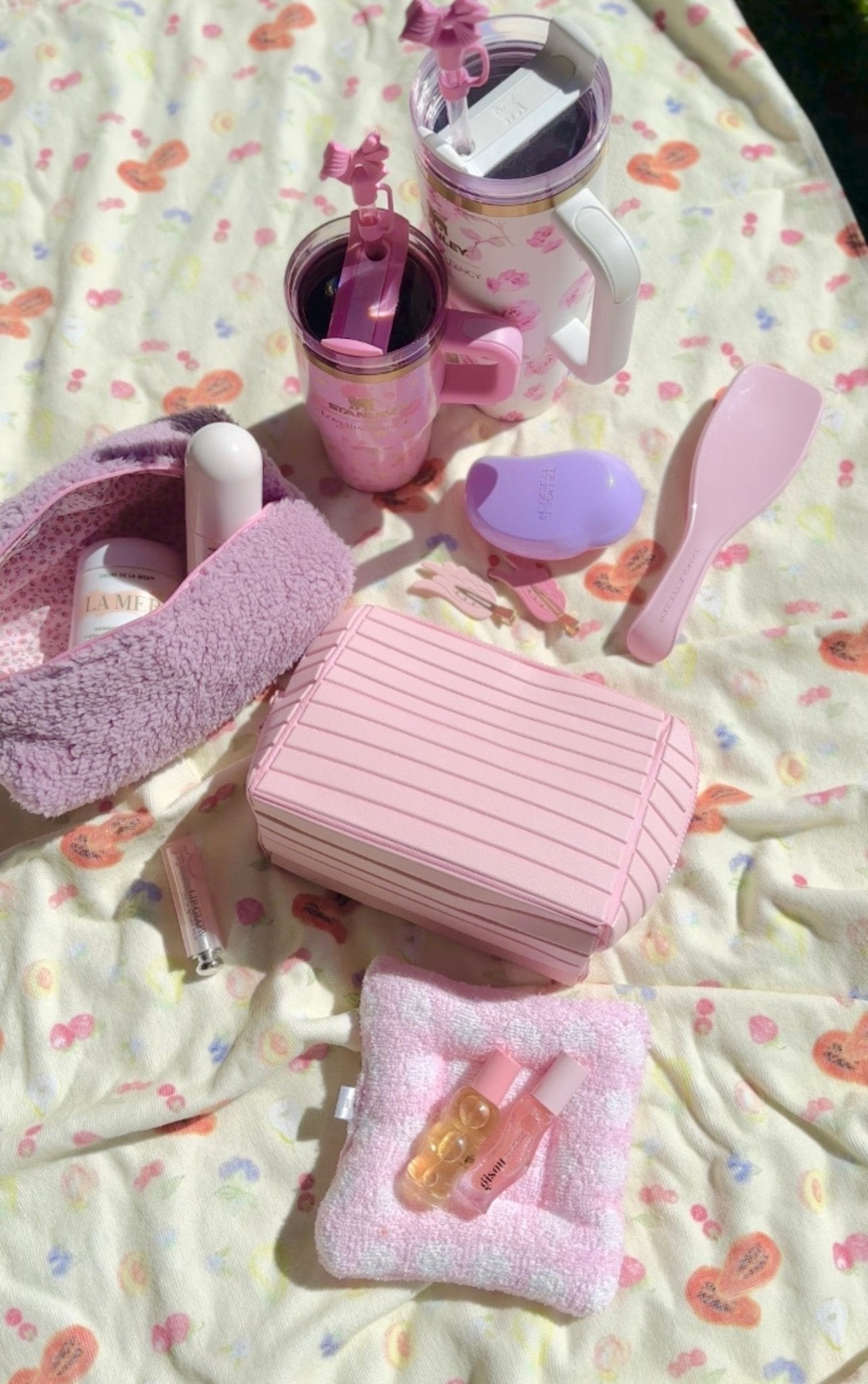 Pink compact flex cosmetic case with striped front, top handle, and hinge lid