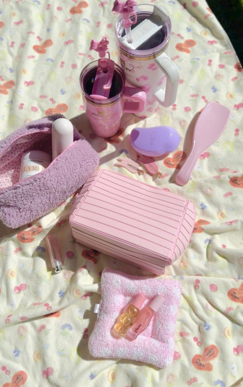 Pink compact flex cosmetic case with striped front, top handle, and hinge lid