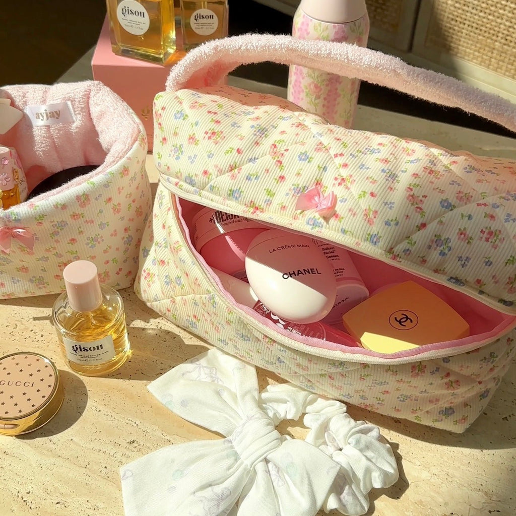 Cream floral mini handbag with arched handle, white bow, and zip-top opening