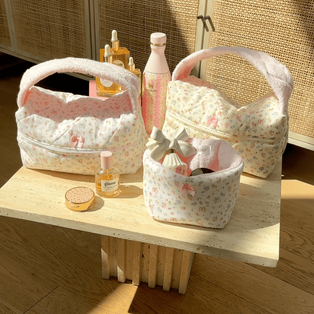 Floral fabric handbag with arched handle and top zipper; light pink base