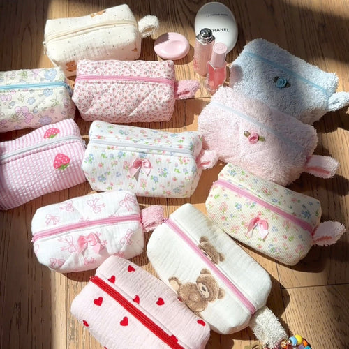 Assorted mini keychain bags with pastel prints and terry finishes, zipper pouches