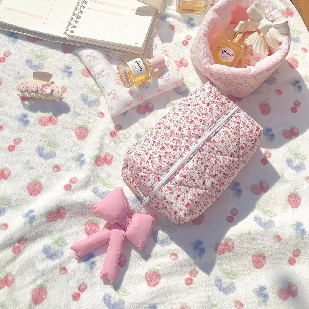 Floral zip pouch with handles ribbon detail, pink interior and full-length zipper seam.