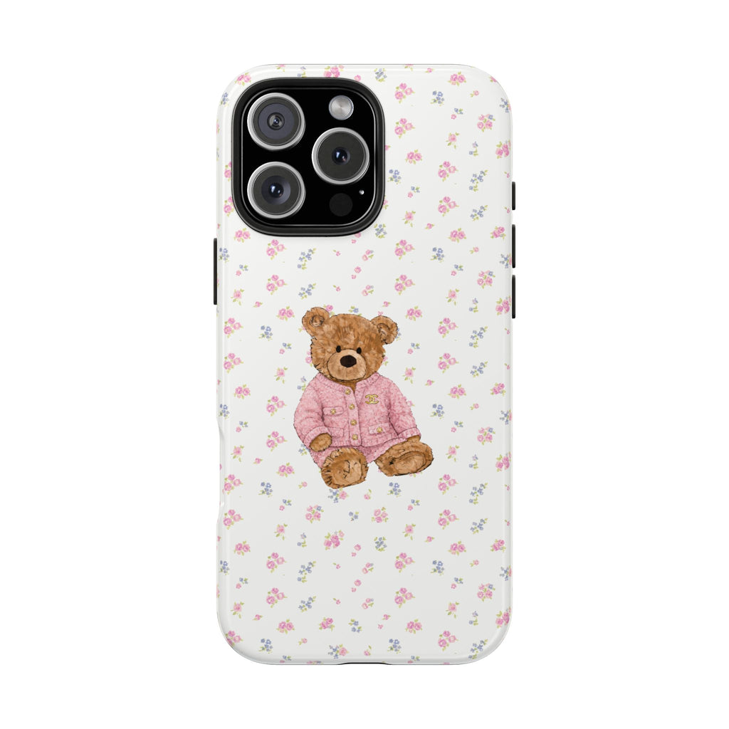 White phone case with pink floral print and teddy bear in pink jacket