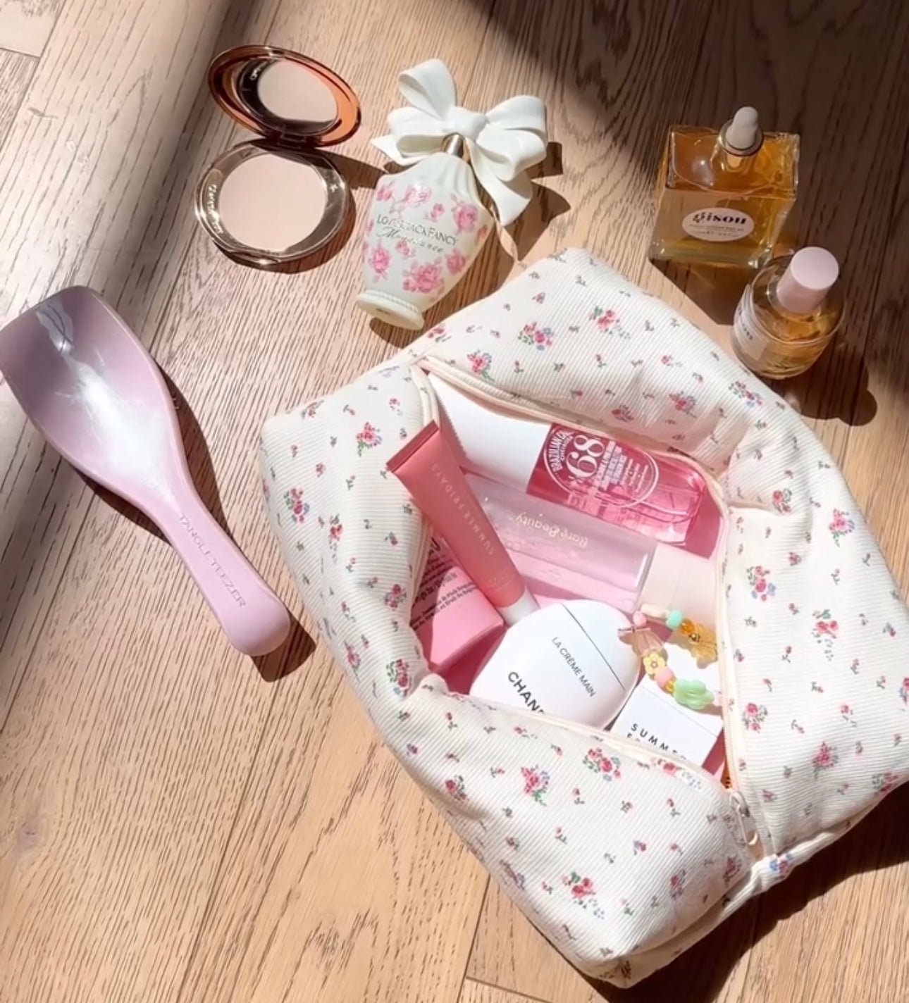Beige floral zip pouch with light pink zipper, interior fabric visible in open bag