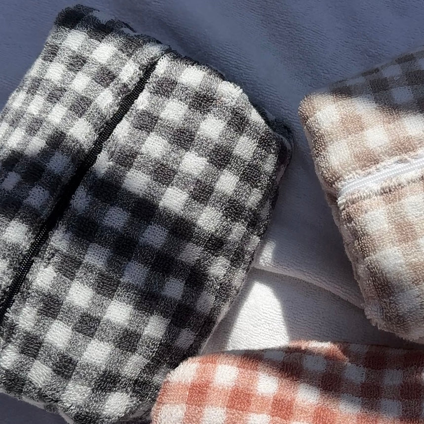 Vintage black gingham fabric with dark trim, folded edge detail close-up.