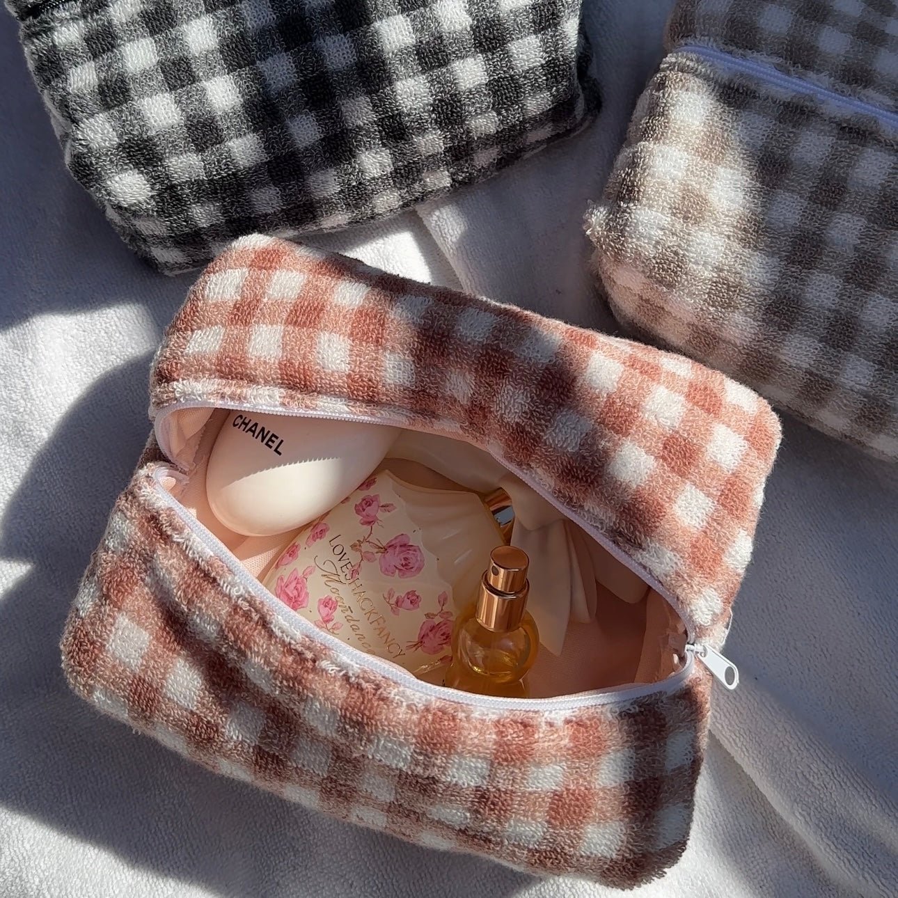 Burnt orange gingham zip pouch, open top with zipper and soft fabric lining.
